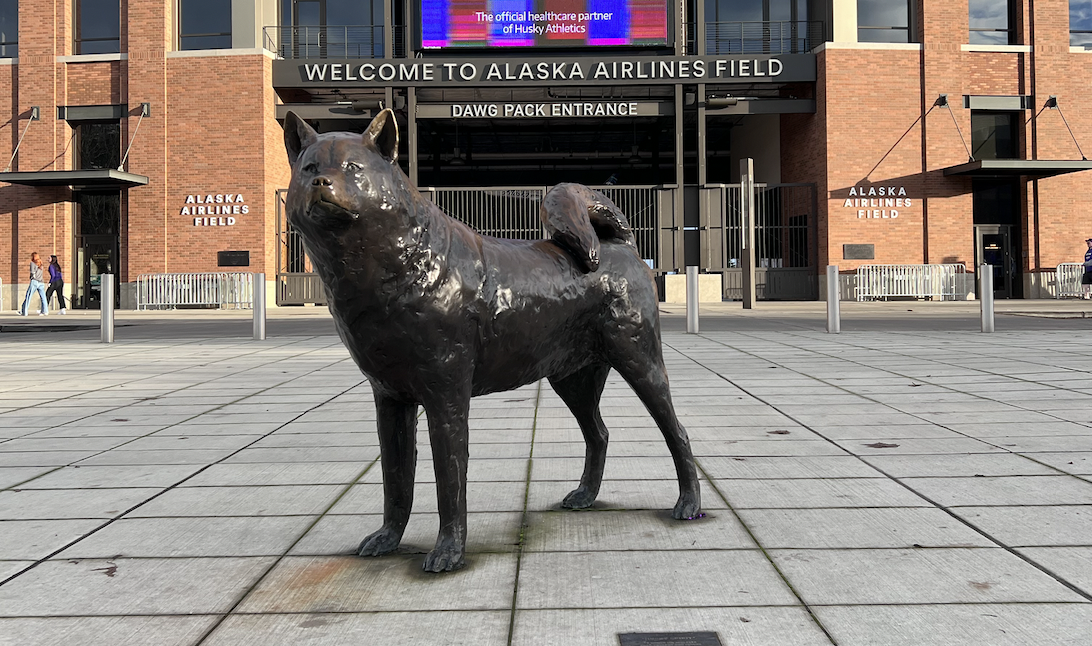The front of Husky Stadium with a bronze husky statue guarding the front.
