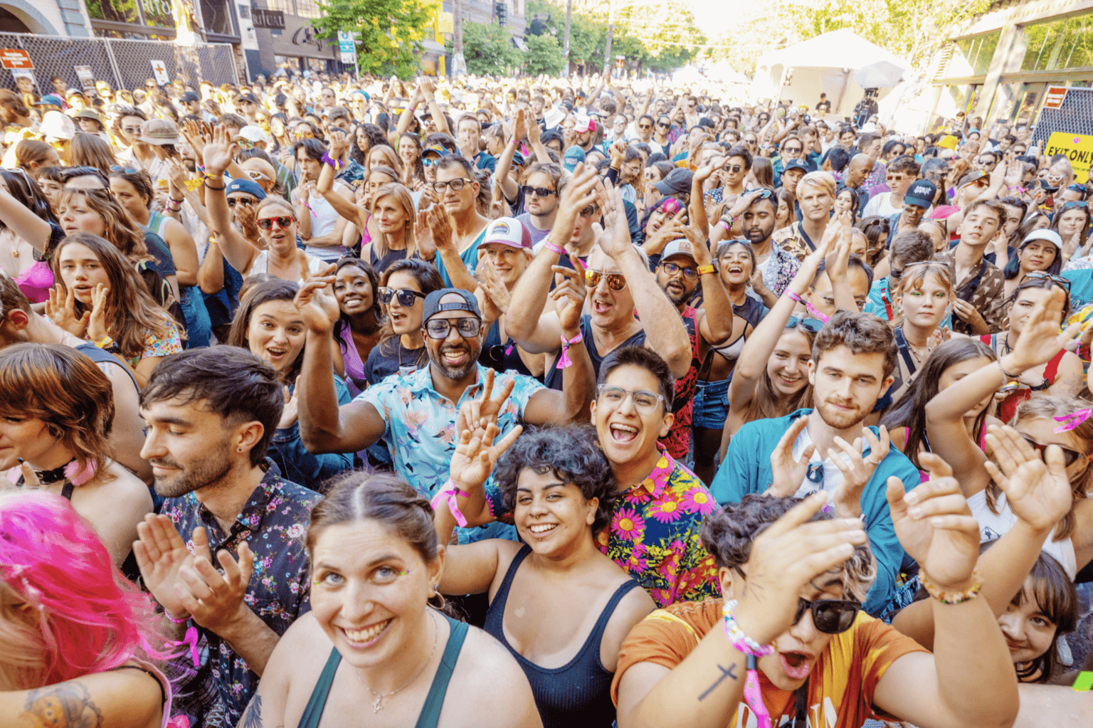 A large crowd of people wave and cheer at the 2023 Capitol Hill Block Party in Capitol Hill, Seattle, Washington.