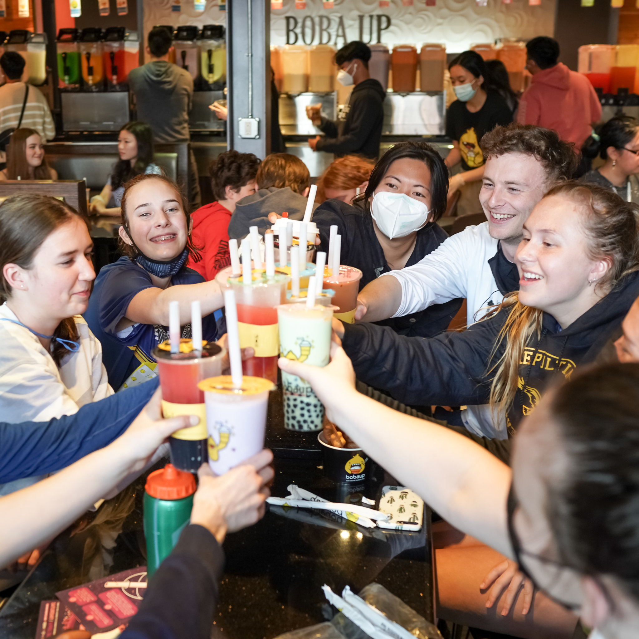 A group of people cheers boba drinks during Boba Fest in Seattle, Washington