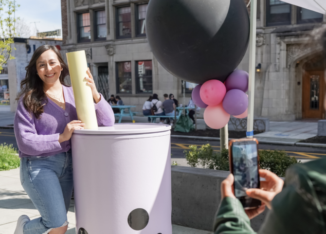 A person poses next to a giant boba drink in the U District during National Boba Day and the Seattle Boba Fest.