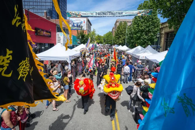 A street fair in the U District with a parade led by lion dancers.