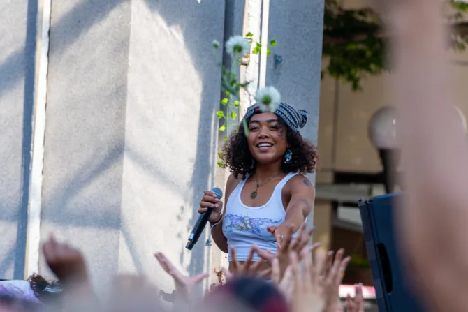Seattle singer UMI throws flowers to a crowd in Westlake Park during Downtown Summer Sounds 2023 in Seattle, Washington.