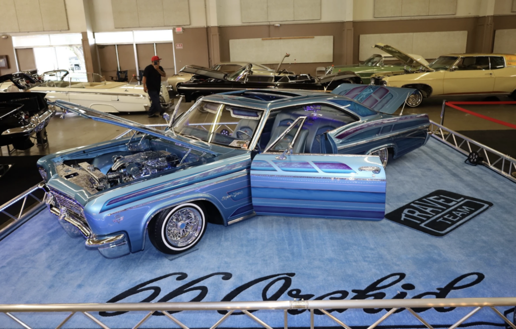 A blue lowrider car at an annual convention