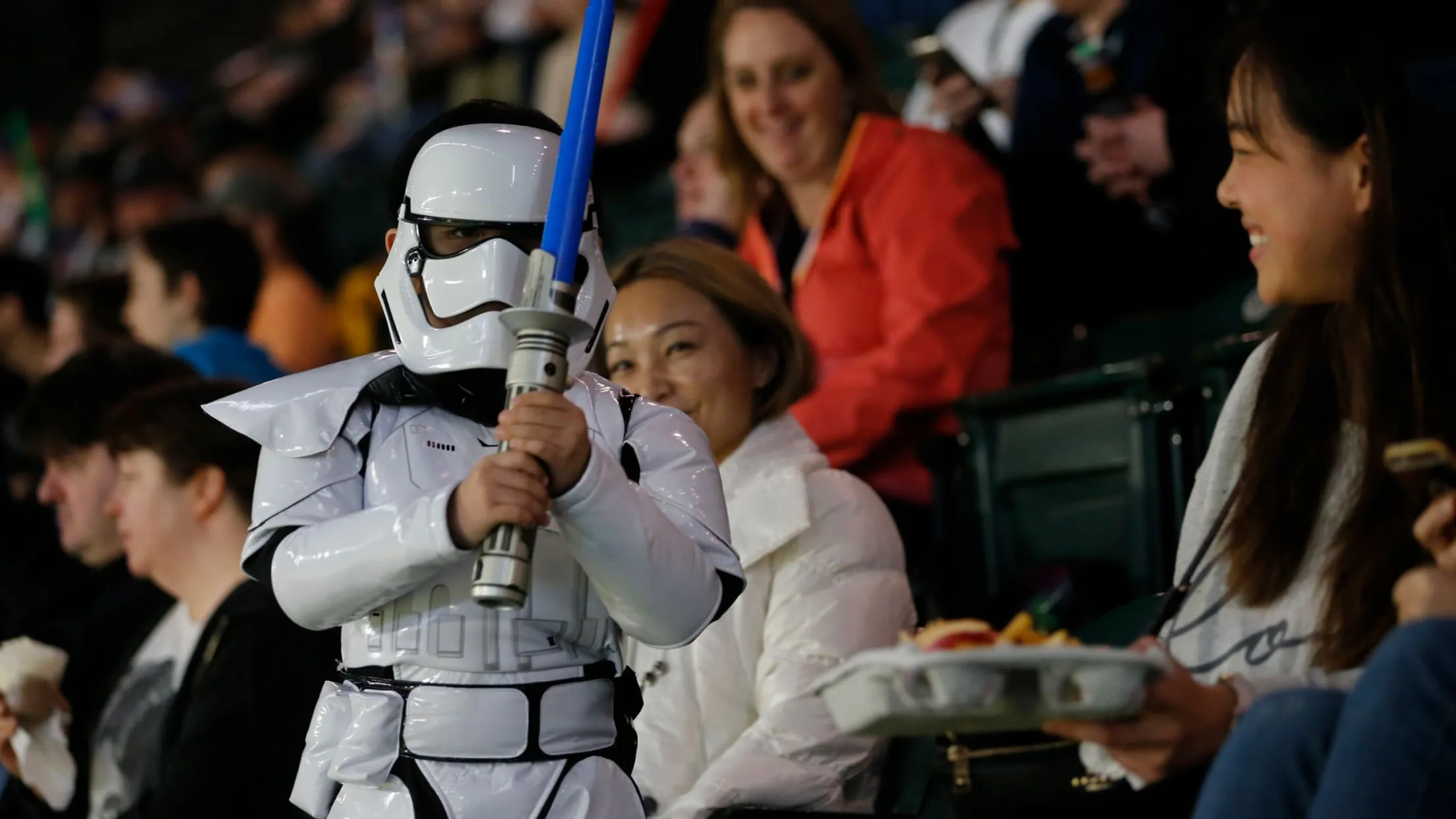 A child dressed as a Star Wars character holds a light saber inside of T-Mobile Park during a Star Wars Night for the Mariners.