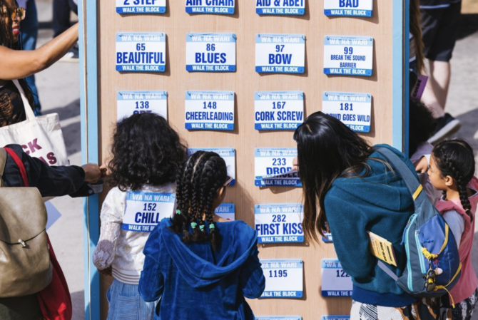 A group of people look at art at the annual Walk the Block festival in the Central District, Seattle.