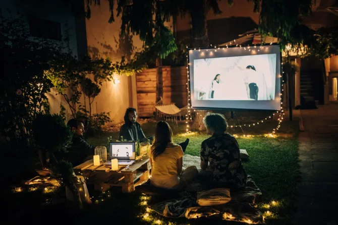 Friends watching a film outdoors