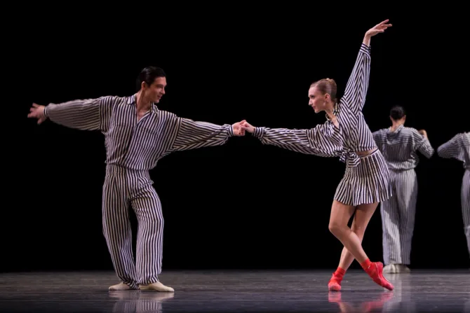 A male and female baet dancer perform together onstage.