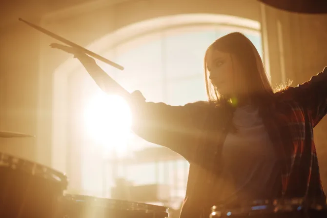 Girl drumming in sepia tones