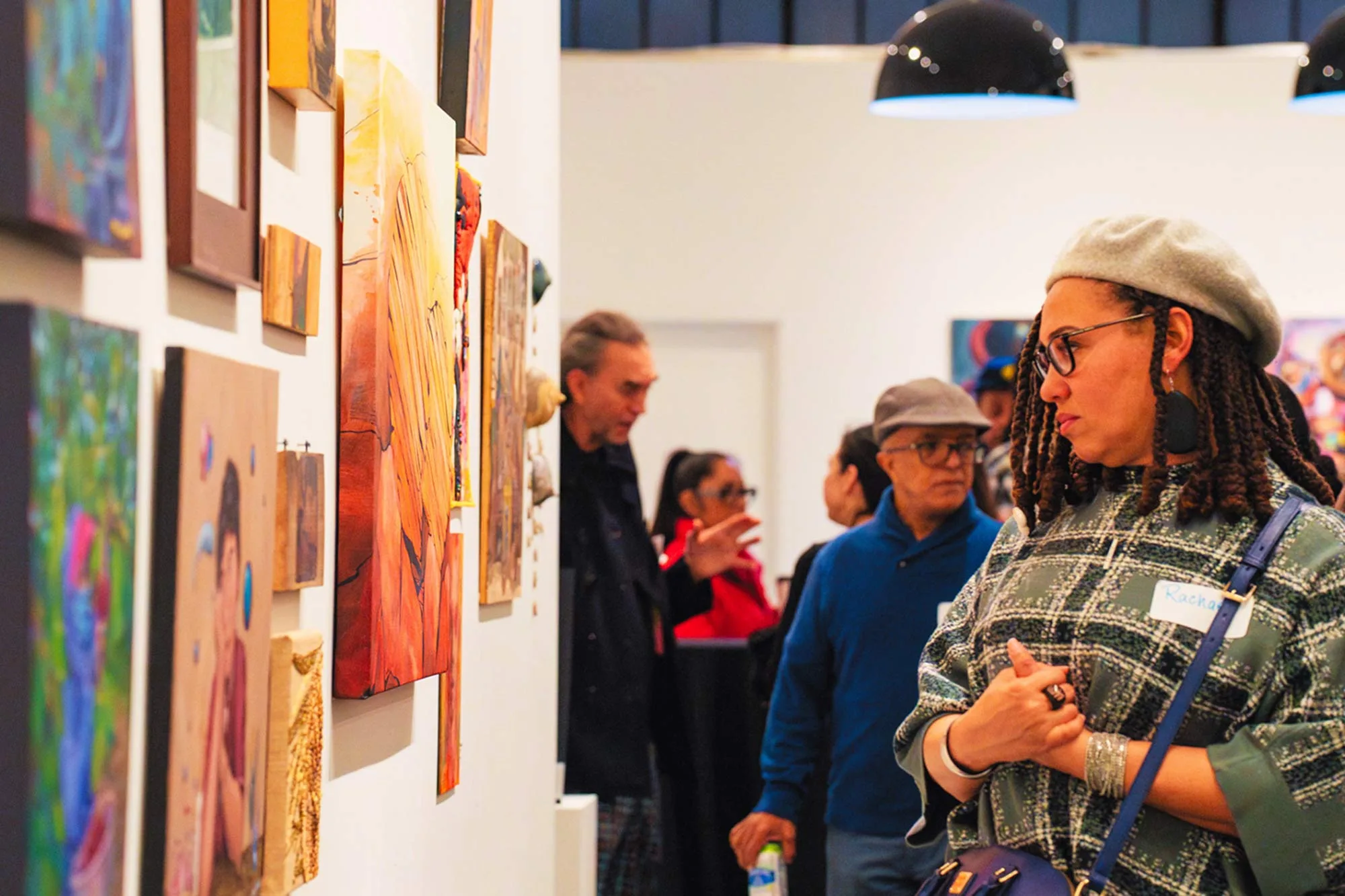 An attendee observes the artwork on display at the 2025 ACES gallery